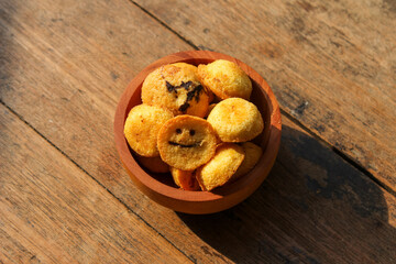 Kue bolu kering or Dried sponge cake in a small wooden bowl with wooden background