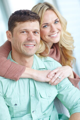 Portrait, hug and happy couple in home for love or bonding together to relax in living room. Face, man and woman in house together to embrace for support, marriage or relationship commitment