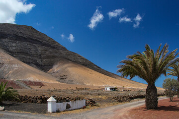Egzotyczny krajobraz, wyspy kanaryjskie, wyspa Lanzarote, w tle niebieskie niebo i białe chmury © anettastar