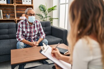 Cheerful senior man radiates joy at psychology clinic, exhibiting a confident, toothy smile while wearing a medical mask