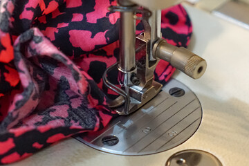 Close up of a woman's hand using a sewing machine