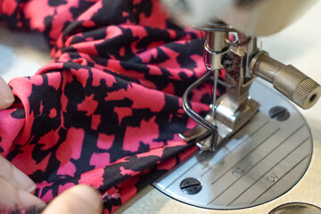 Close up of a woman's hand using a sewing machine