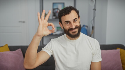 Smiling man making okay gesture in a modern living room