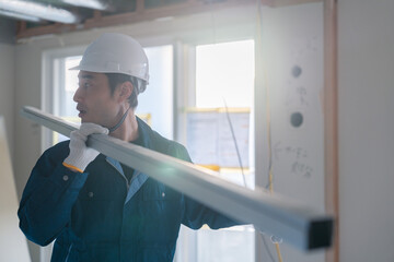 建設現場で資材を運ぶ男性の職人