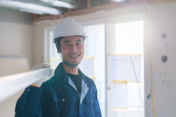 建設現場で資材を運ぶ男性の職人
