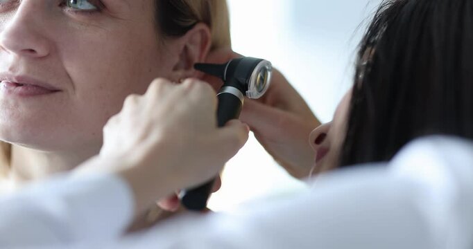 ENT conducts medical examination of ear to woman. Hearing test in adults concept
