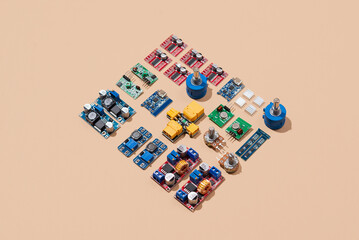 Microcontrollers, boards, sensors, leds and modules for learning the basics of electronics. Various electronic components for soldering arranged in creative arrangement
