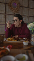 A young woman enjoys a meal in a cozy restaurant setting, exuding a sense of casual dining and lifestyle.