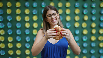Beautiful hispanic woman in glasses delightfully eating traditional japanese melon pan snack on...