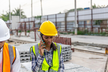 A mechanical engineer using software or application through electronic device or tablet or gadget to work in a construction site.