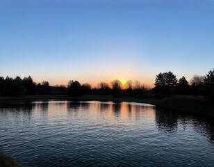 Obraz premium Sunset over a tranquil pond