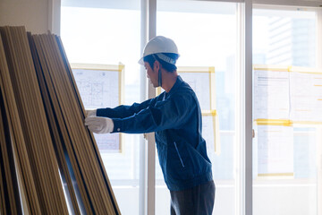 リフォーム工事の現場で石膏ボードを運ぶ職人