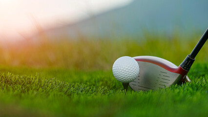Golf clubs and balls on a green lawn in a beautiful golf course with morning sunshine.