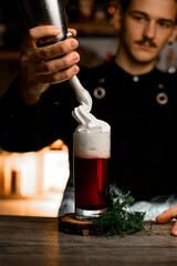 Creamy Final. Bartender adds an unexpected twist, pouring cream over the cocktail.