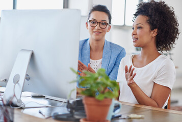 Female people, coworker and computer in office for brainstorming, project or colleague as web designer. Women, technology and discussion for communication, teamwork or collaboration in digital agency