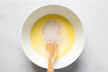 Overhead view of Activated yeast with milk and melted butter, top view of dry yeast granules on milk, process of making bread