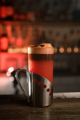 Cocktail adorned with a pair of coffee beans graces the counter.