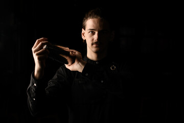 Mixology mastery. Bartender shakes concoction in the dark.