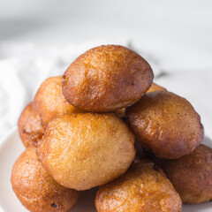 Overhead view of nigerian puff-puff on a white plate, nigerian fried dough balls, flatlay of homemade bofrot on white dish