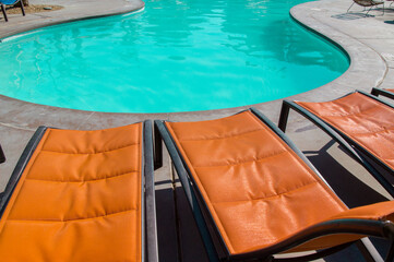 Orange outdoor chaise lounge pool chairs at swimming pool