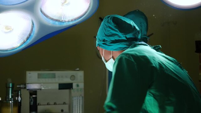 Surgeons performing surgery in operating room. Medical team in serious cases patient heart attack, pulse pump by hand, health care safety. Professional teamwork monitoring working together