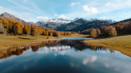 Fototapeta premium A picturesque valley featuring a calm lake mirroring mountains and vibrant autumn trees, creating a harmonious blend of tranquil waters and beautiful fall foliage.
