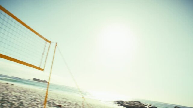 Handheld action shot of beach volleyball players playing and returning a serve