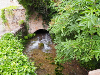 puente de piedra dovelado a través del cual discurren las claras aguas procedentes de las montañas, villa de rivert, lérida, españa, europa