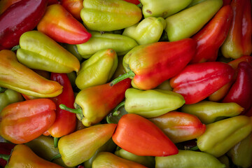 In a variety of red, green, and yellow, bell peppers brighten dishes and please plates with their colorful appearance. Background fresh vegetables bell pepper top view