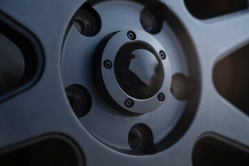 Closeup image of a modern car wheel, highlighting the intricate design of the center cap