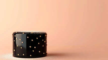 modern black cake with a glossy finish and minimalistic gold dots, set against a pale peach background with text space
