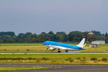 Blue Airplane Landing on Green Runway