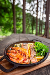 Healthy baked salmon steaks with greens and asparagus in a black cast iron skillet. A delicious low-carb breakfast.