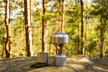 Obraz premium A kettle on the fire during a hike in the mountains.
