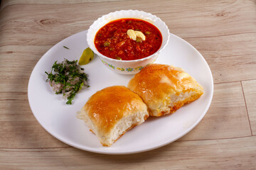 Pav Bhaji is a fast food dish from India, Thick and spicy vegetable curry, fried and served with a soft bread Bun Pav and butter. selective focus