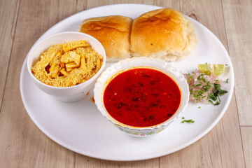picy Misal Pav or usal Pav is a traditional snack or Chaat food from Maharashtra, India. Served with chopped onion, lemon wedges and farsan. Selective focus