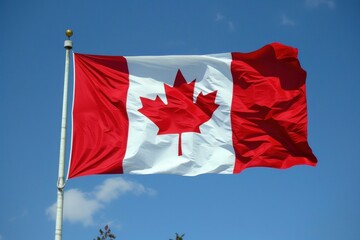 Vivid image of the national flag of canada fluttering in the breeze, with a clear blue backdrop