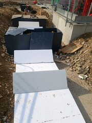 Insulating foundations with rigid foam boards and moisture barriers at construction site. Foundation insulation and thermal protection concept.