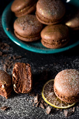 Macaroons with chocolate cream on a dark background.