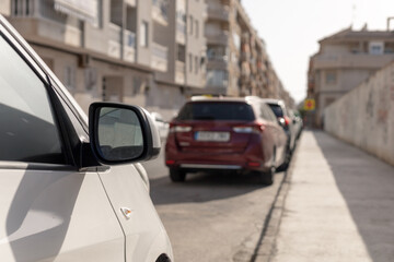 Line of parked cars along a narrow city street. Perfect for content related to urban transport, city living, automotive articles, or traffic management strategies. Parking price.