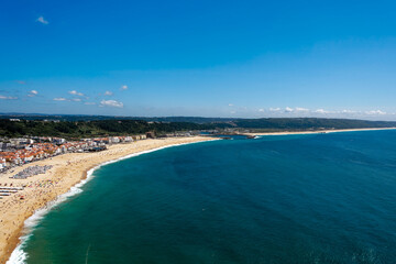 Aerial view of scenic landscape with beautiful sandy beach at Portuguese town of Nazaré on a sunny summer day. Photo taken July 16th, 2024, Nazaré, Portugal.