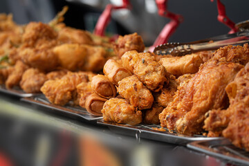 A table full of fried food including chicken, chicken wings, and chicken tenders. The food is piled high and looks delicious