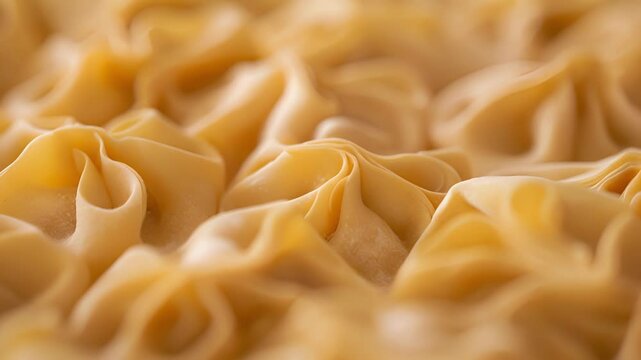 A closeup of handformed pasta dumplings with intricate folds and creases ready to be cooked to perfection.