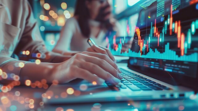 A close-up of hands using a laptop, analyzing financial graphs and data in a modern office environment.