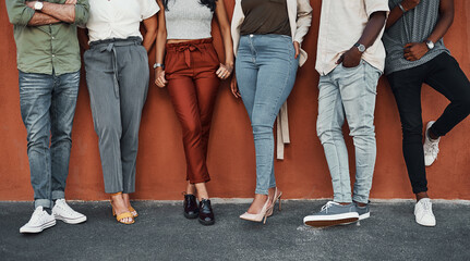 Wall, legs and business people with shoes, closeup and fashion with stylish outfit. Group, design team and high heels with sneakers, modern office and illustrator company with diversity or creativity