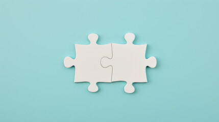 two white puzzle pieces matching together againt light blue background