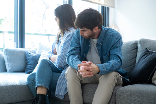 Close-up of unhappy young couple sitting apart have relationship problems, think about breakup or divorce. Family lovers, distraught men and women, avoid talking and suffer from betrayal 