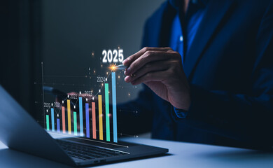 The 2025 New Year business goals concept. Businessman analyzes graph of trend market growth in 2025...