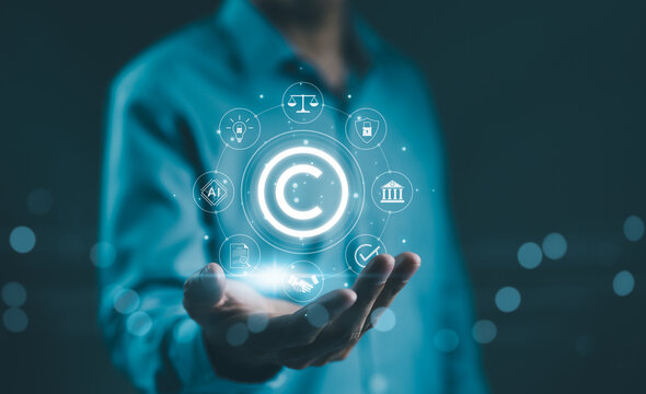 Digital copyright, patent concept. Businessman hold digital icons representing copyright, intellectual property, patents, legal protection, and safeguarding digital and intellectual assets. trademark,