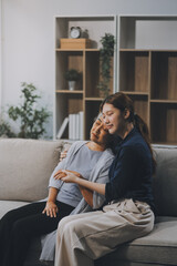 Fototapeta premium Sad teen granddaughter hugging depressed mature grandmother, giving support, help, comforting, consoling granny. Teenage daughter girl and middle aged mother going through family problems